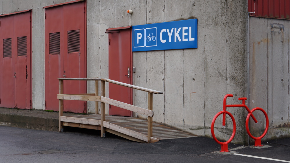 Cykelgarage med en röd cykel utanför.